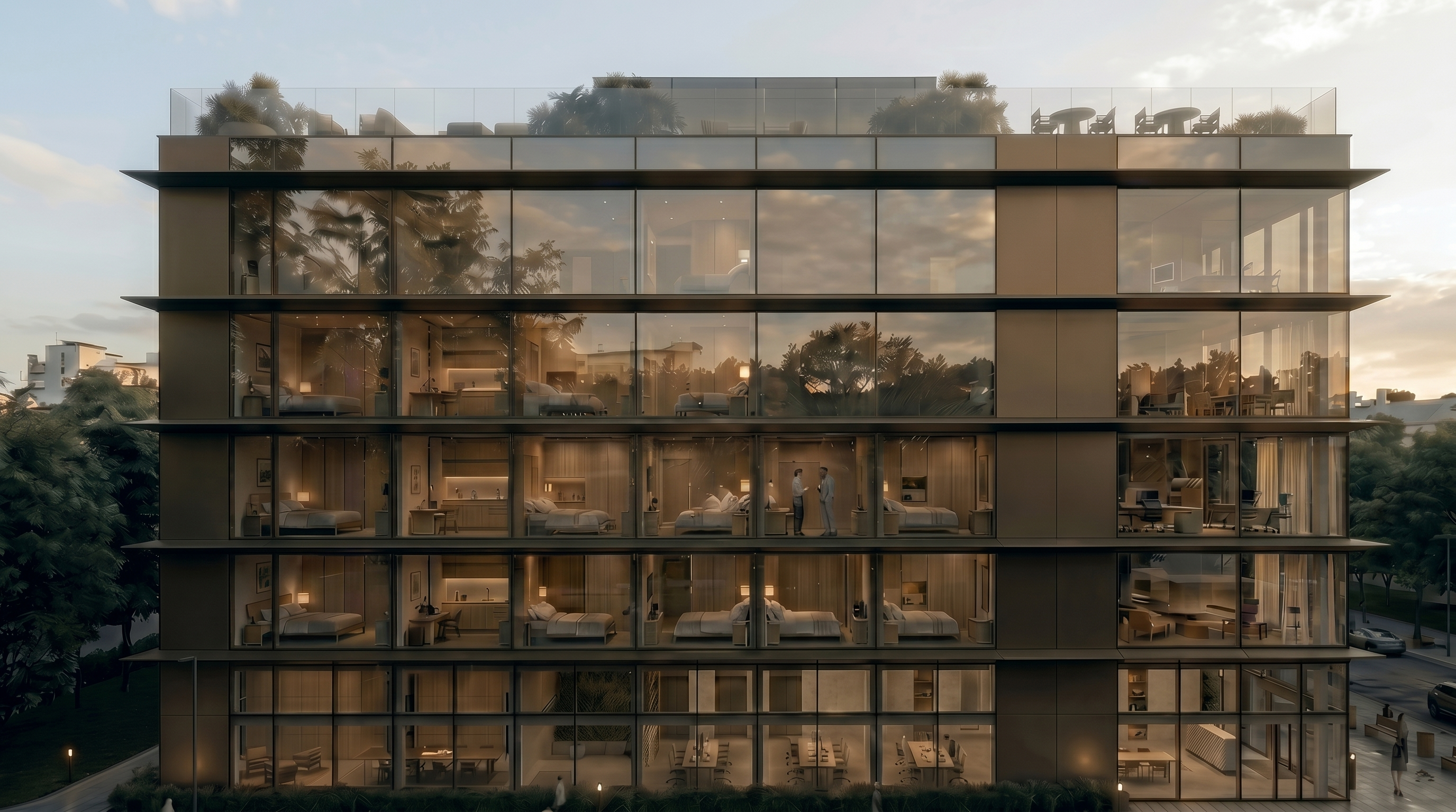 HALO purpose-built accommodation at dusk — glazed facade revealing furnished studios and rooftop greenery